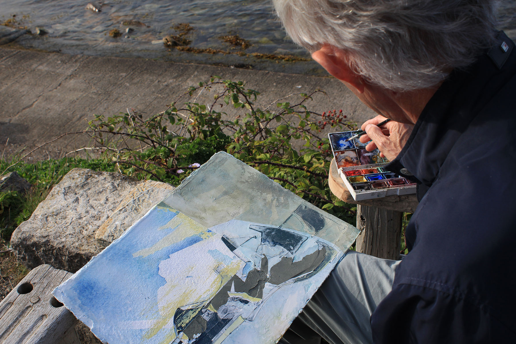 Jeremy Gardiner painting plein air with brush and watercolours, Ballard Point in the background